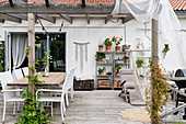 Gemütliche Terrasse mit Pergola und Holzboden am Haus