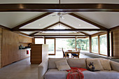 White sofa in open-plan interior with fitted kitchen and dining area in background