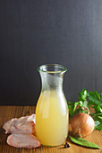 Homemade chicken broth in a glass carafe