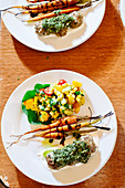Roasted carrots and balsamic drizzle with lamb meatballs and greens pesto and corn salad