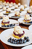 Viele Heidelbeer-Shortcakes mit Vanilleeis auf Tellern (Südstaatenküche)