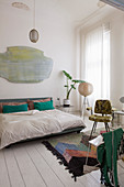 Retro furniture and splashes of colour in white bedroom in period building