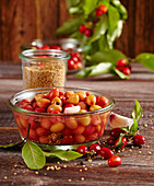 False olives: pickled cornelian cherries in a glass bowl with vinegar, bay leaves, mustard and garlic