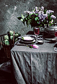 Tablecloth setting with artichokes, flowers and red wine