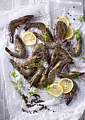 Fresh Tiger Prawns and lemon slices placed on parchment paper