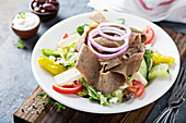 Gyro salad with thinly sliced meat and vegetables, healthy greek inspired lunch