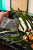 Cushions on sofa with botanical pattern, orchid in the foreground