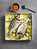 Oven-roasted seabream with potatoes and courgette served with red mojo