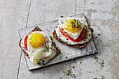 Fried eggs on black bread with herb quark