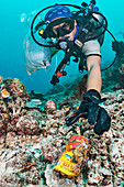 Scuba diver collecting waste food can