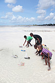 Racing toy boats on a beach, Zanzibar