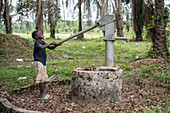 Young children pumping water from a well, Ganta, Liberia