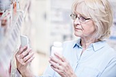 Senior woman checking medicine on phone
