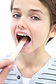 Boy with mouth open and tongue depressor