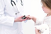 Doctor placing pulse oximeter on girl's finger