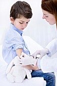 Doctor giving boy injection in arm