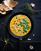 Yellow vegan lentil and pumpkin dhal with toasted unleavened bread (India)