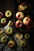 A basket of organic apples on a wooden surface