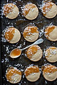 Shortbread cookies dipped in caramel and coconut, on an antique baking sheet