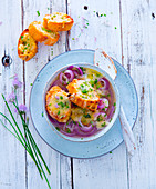 Red onion soup with cheese croutons and chive blossoms