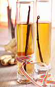 Homemade vanilla and ginger vinegar in cylindrical glasses with a bow