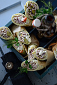 Pancake rolls with sausage salad and gherkins