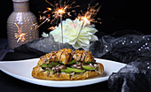 A croissant with kiwi and chocolate cream decorated with sparklers