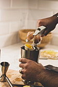 An egg with being broken into a cocktail maker with an egg separator