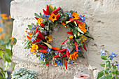 Colorful wreath made of chili peppers and edible flowers