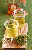 Homemade thyme vinegar with honey in small glasses on a wooden board