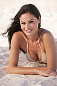 A young brunette woman wearing on a beach wearing a silver bikini top