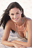 A young brunette woman wearing on a beach wearing a silver bikini top