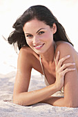 A young brunette woman wearing on a beach wearing a silver bikini top