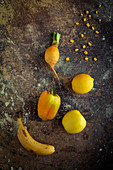 Mix of fruits and vegetables in yellow color on rusty background