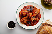 Chicken legs with tomato sauce and fresh basil