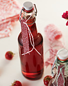 Homemade strawberry syrup in a flip-top bottle