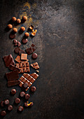Selection of whole and broken milk and dark chocolate on a dark background