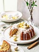 Coconut Easter cake with white chocolate eggs, sliced