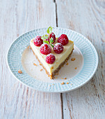 A slice of raspberry cheesecake garnished with mint