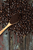 Ein Löffel gemahlener Kaffee auf gerösteten Kaffeebohnen