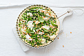 Unbaked pea tart with green beans, goat's cheese and pine nuts