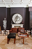 Large clock above fireplace in living room in shades of brown and black