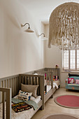 Three pale grey cots along wall in nursery