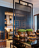 Black dining table with screen and open-plan kitchen in period building