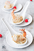 Fried prawns in sauce on porcelain spoons
