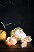 Various citrus fruits, partially peeled