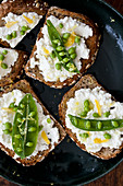Whole wheat toast topped with ricotta, peas, lemon zest and olive oil