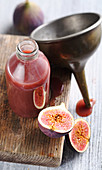 Homemade fig syrup in a bottle with a copper funnel