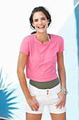 Junge Frau in pinkfarbenem T-Shirt und weißen Shorts