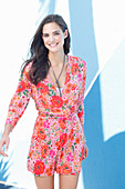 A young woman on a beach wearing a floral dress